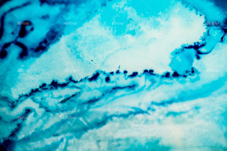 The ink to refill the printer cartridge was spilled onto the white washbasin and the paints blended into abstract drips and patterns.