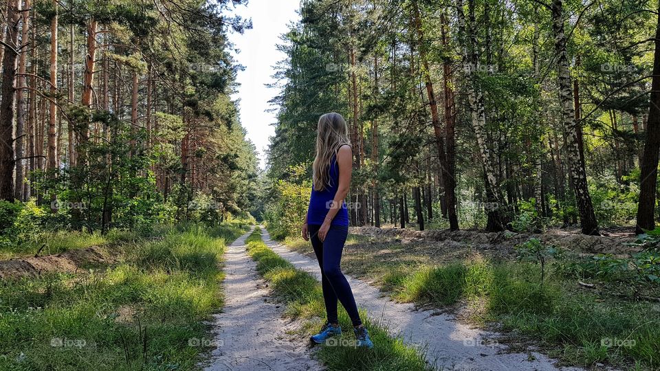 woman in running clothes on forest path