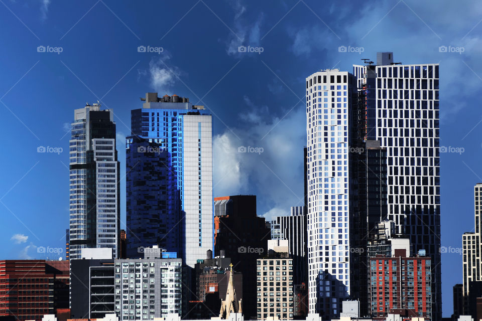 Towering skyscrapers in New York city stand tall like legos seen alongside the FDR drive.