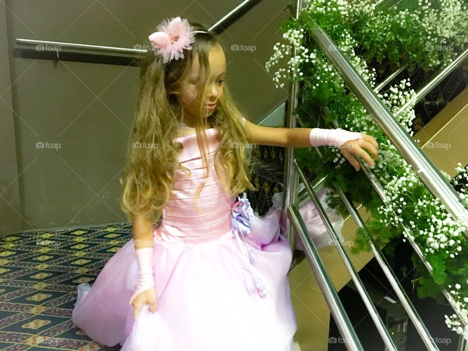 Girl in pink dress moving down through staircase
