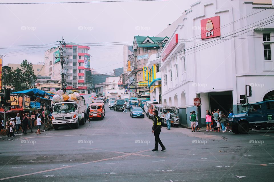 A traffic enforcer in the middle of a busy street.