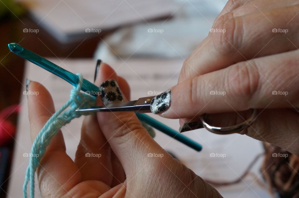 Woman's hands as she begins her craft project with hook needle and yarn