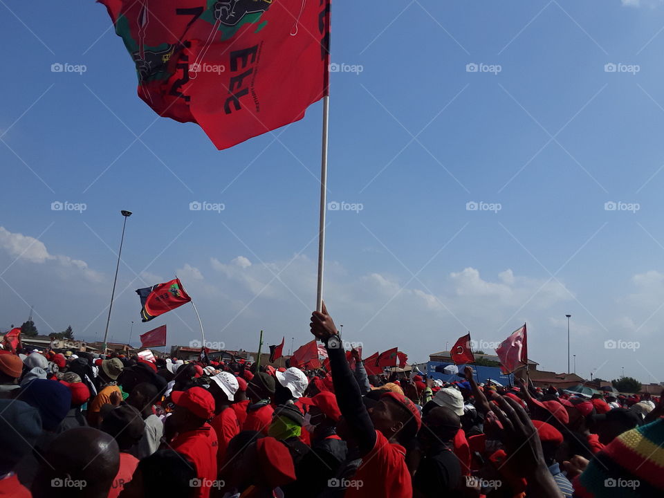 Holding a flag high as the party supporters make a final showdown for elections.
