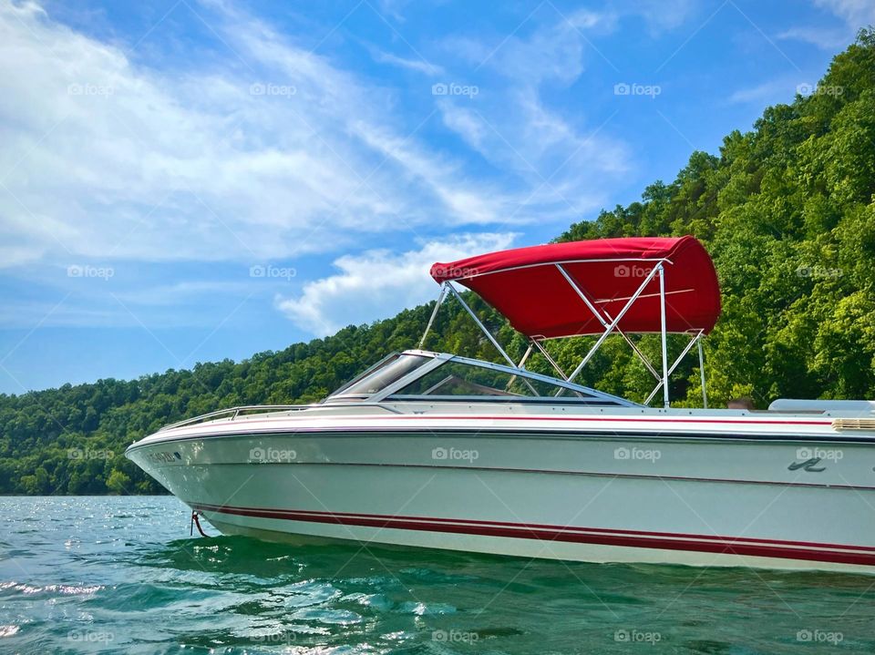 Pretty white and red sea ray boat floating on Lake Cumberland 