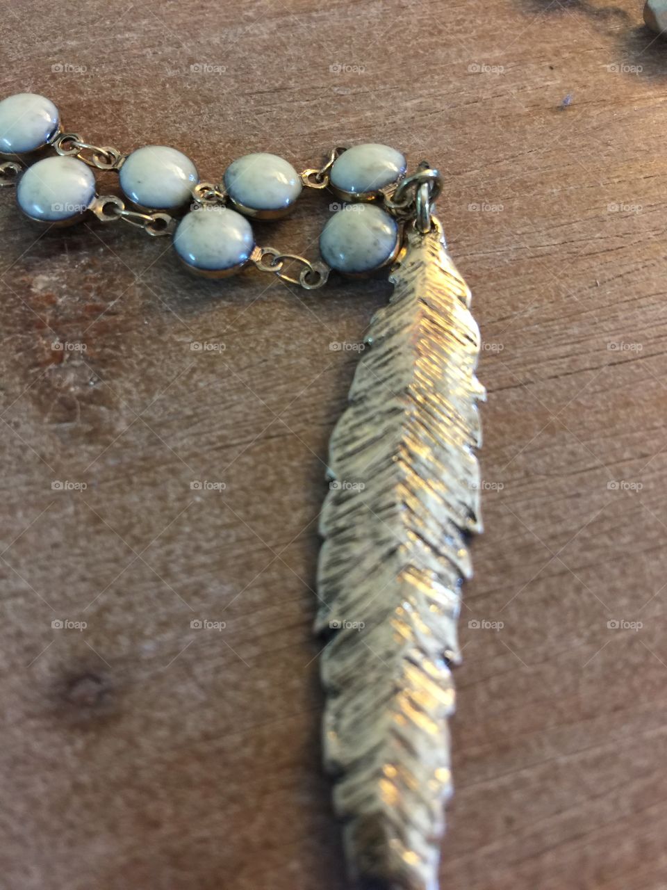 Shot of a boho feather necklace with a western chain.