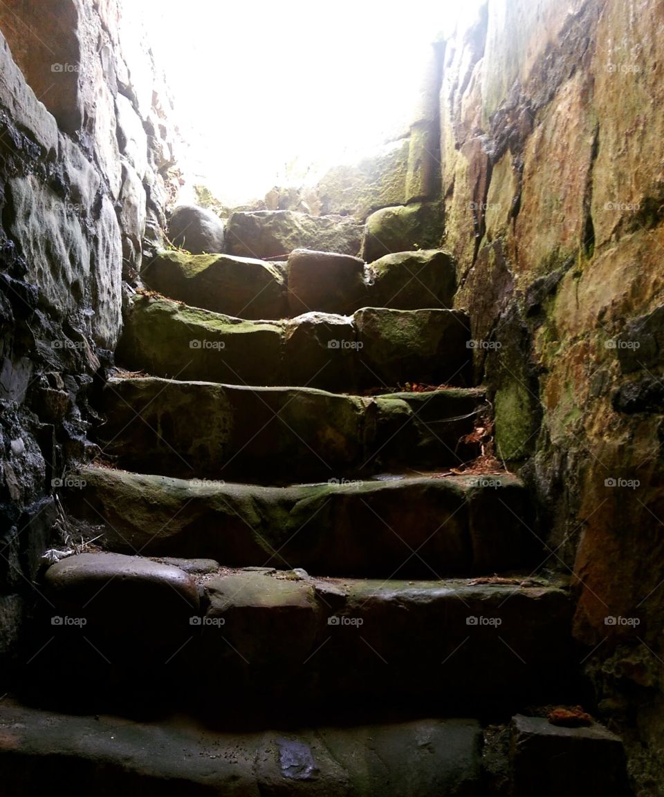 old ruined stone steps leading up to light