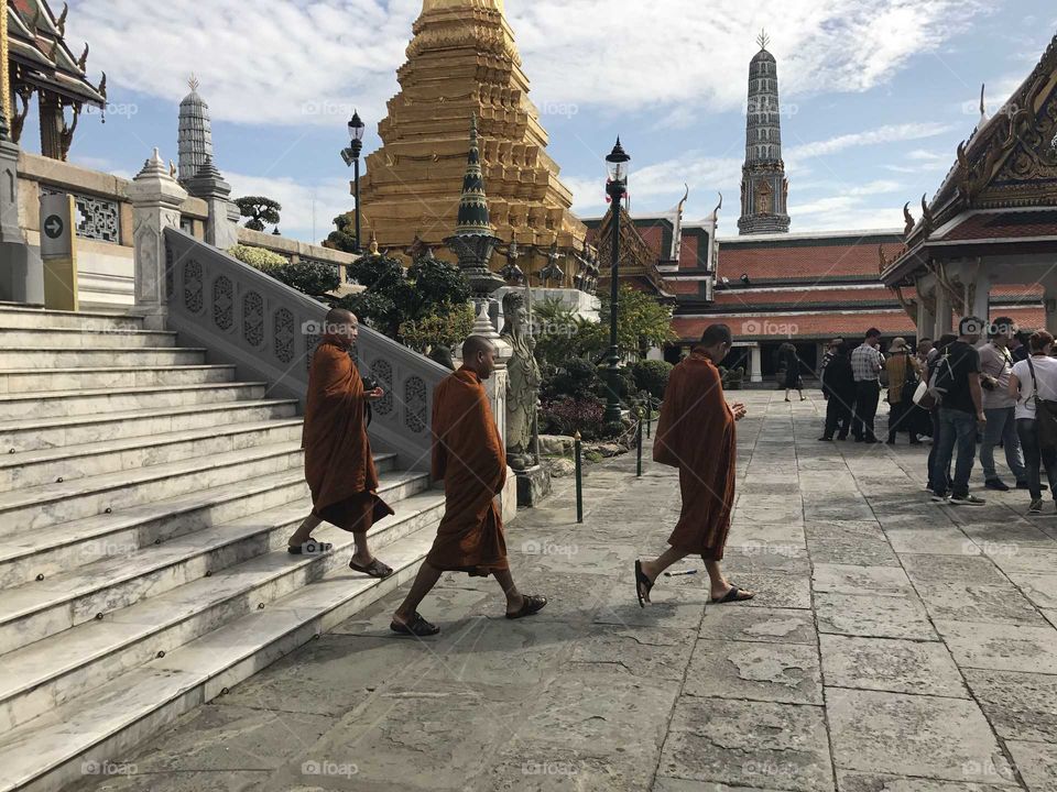 Three monks walking in front of the temple