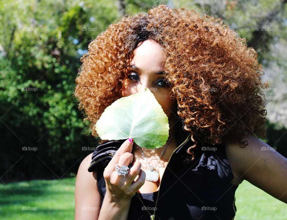 portrait of a lady holding a green leaf