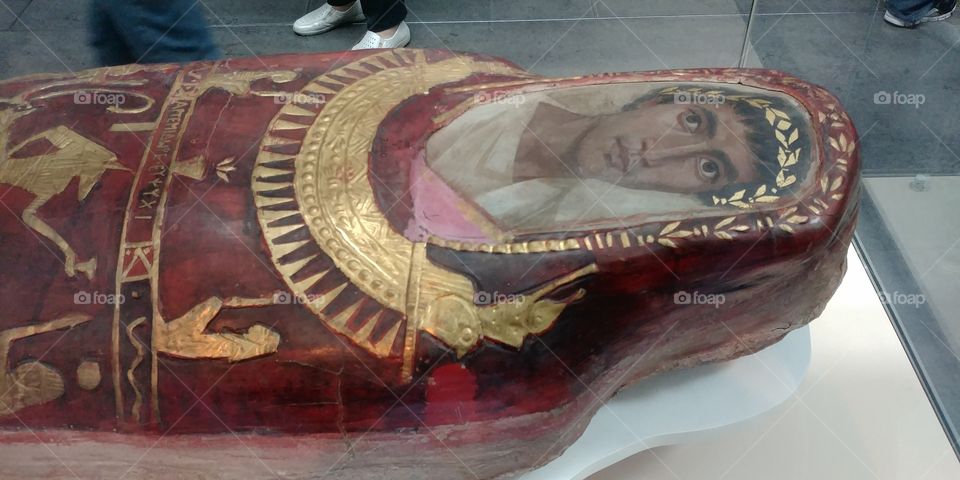 close up of painted head of Egyptian roman mummy in museum display case
