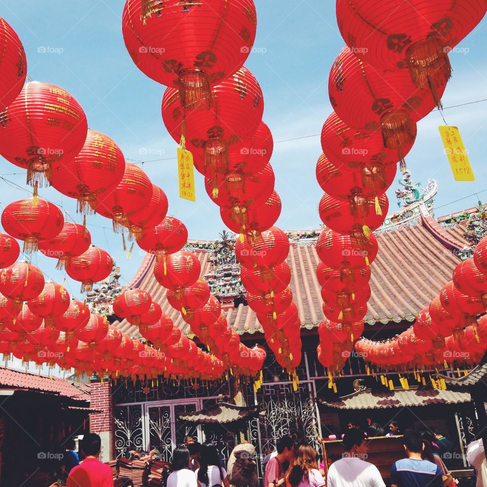 Red Chinese New Year lanterns hang in rows above a Chinese temple in Penang, Malaysia.