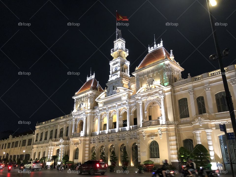 The City Hall of Ho Chi Minh City, Vietnam lit up against a dark night sky.