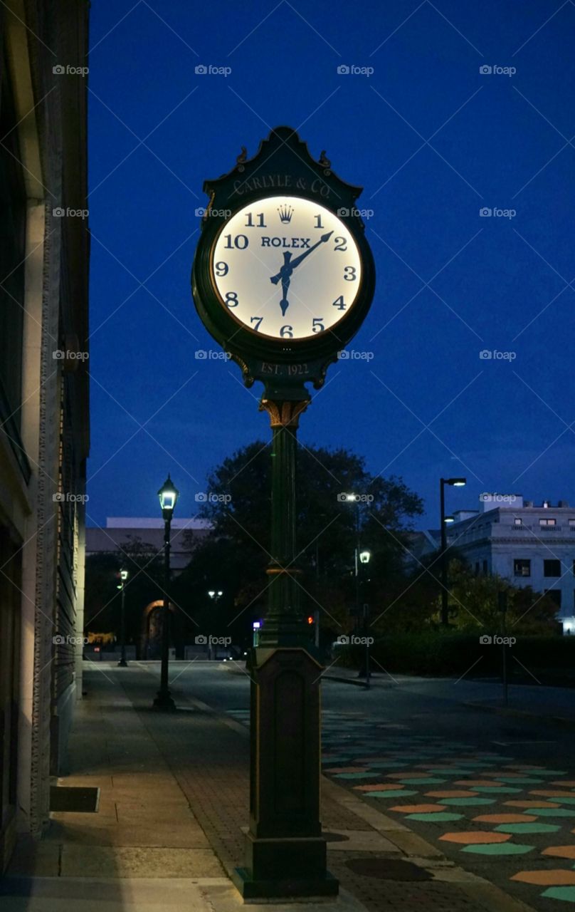 Early morning downtown clock on clear day .
