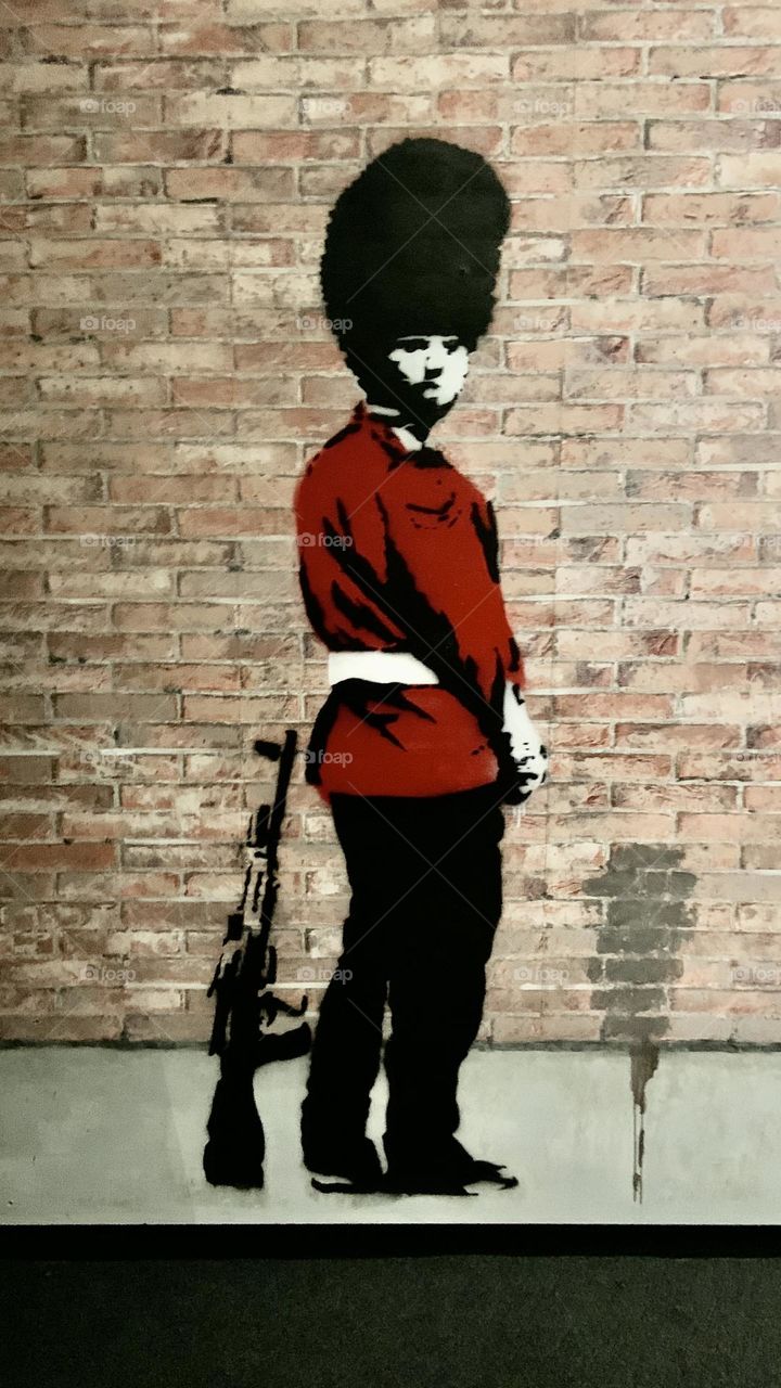 Red policeman jacket against wall . Bansky art 