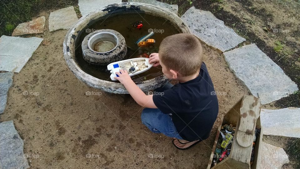 playing . Playing with boats and cars in birdbath