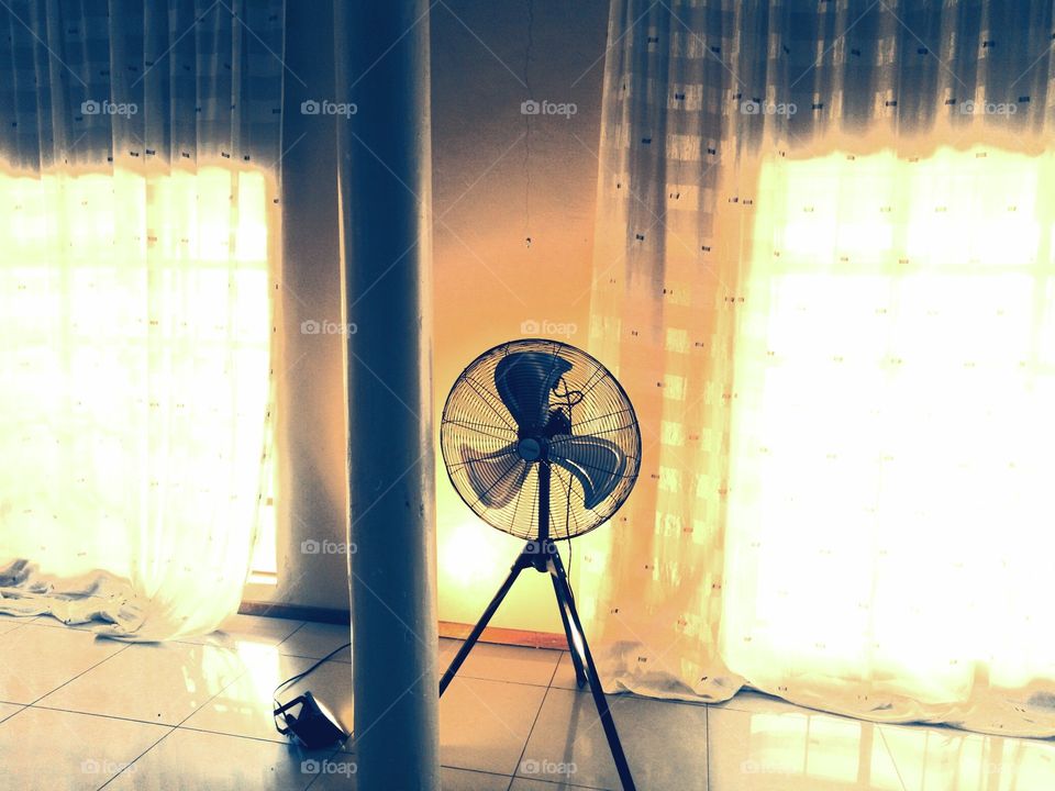 Display of a fan in a complimentary lit room with yellowish light finishing and dark shadow filling