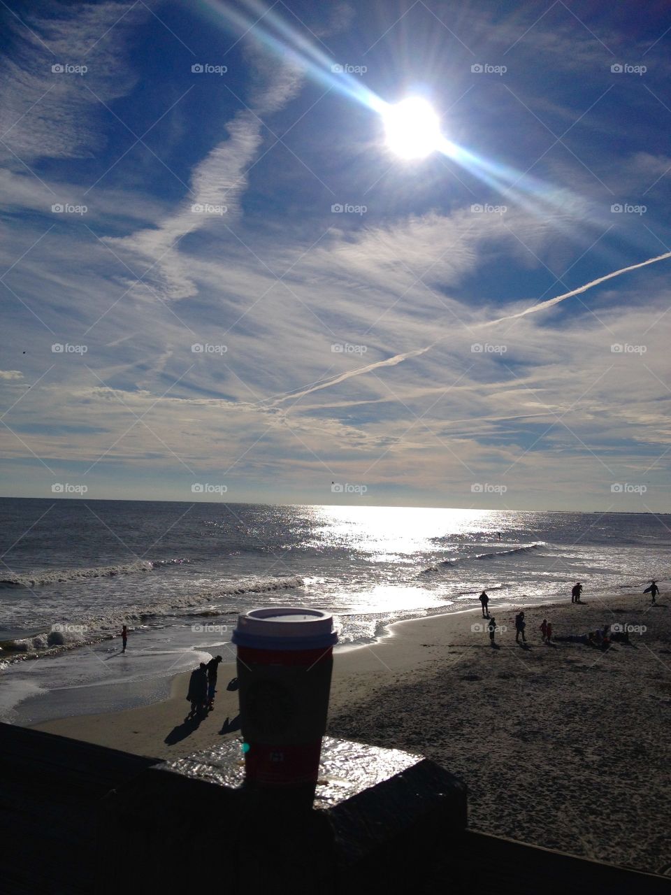 A walk at the beach with cup of coffee at sunset