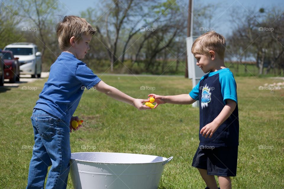 Two little boys sharing and playing together