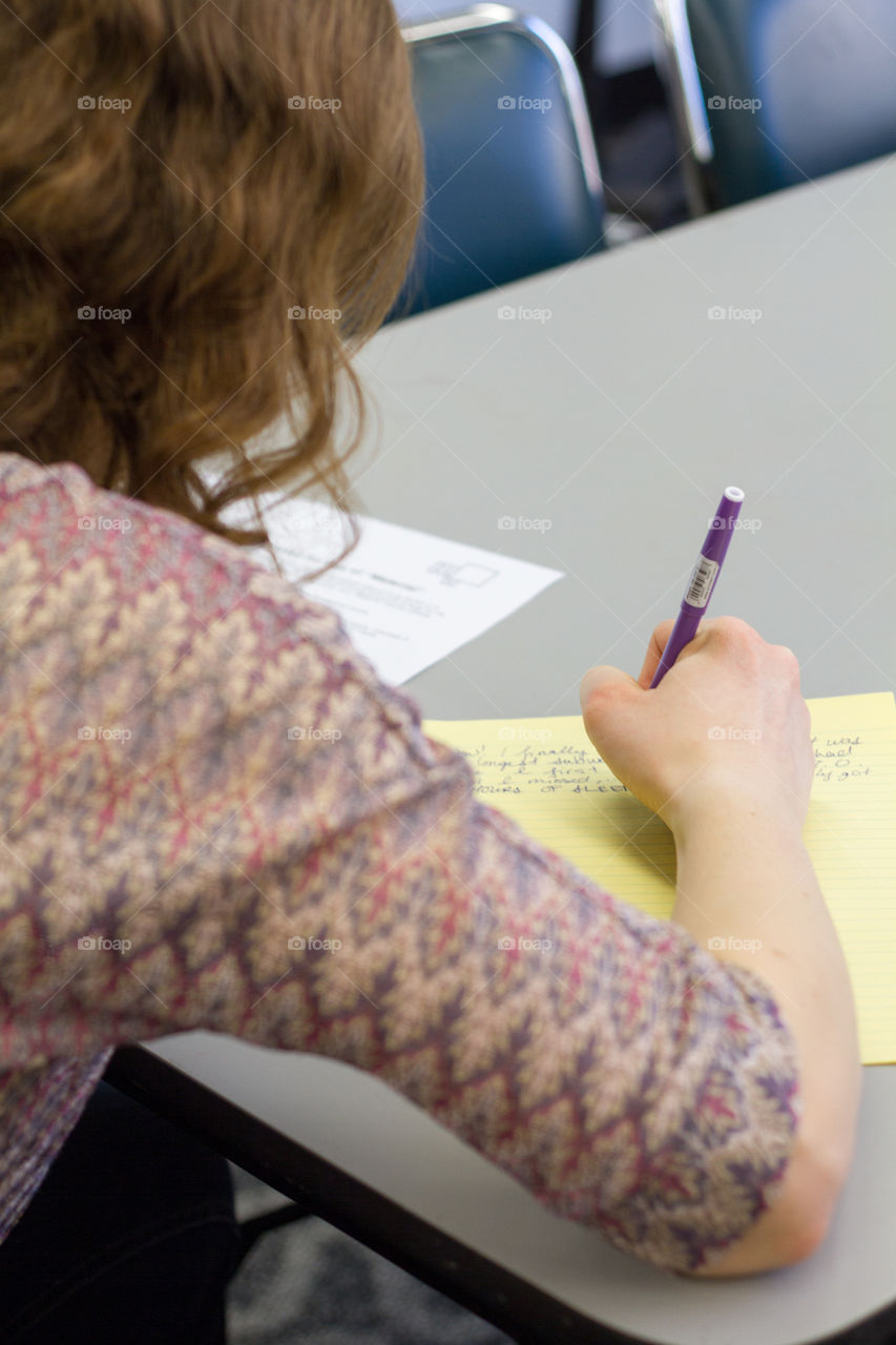 A female student taking notes in a class