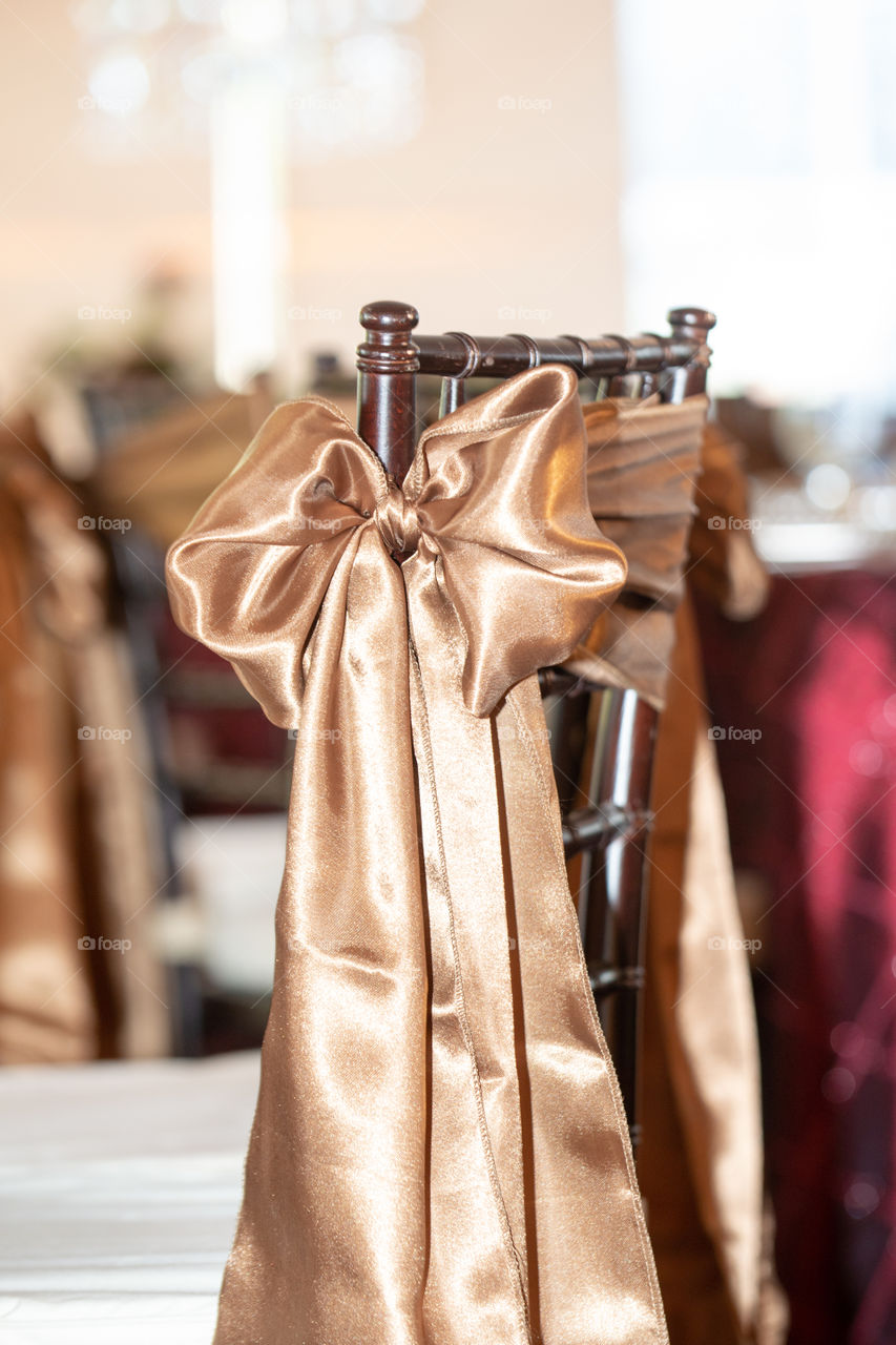 Brown chivari chairs with brown bows and ribbons at wedding reception
