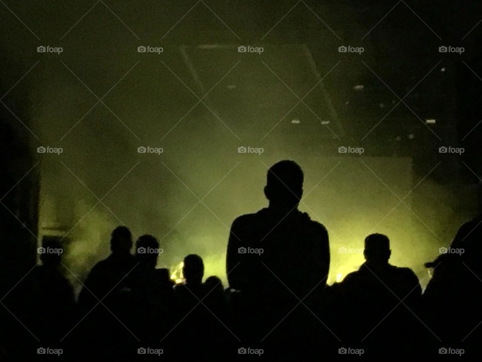 Yellow light and shadows of people at Florida Man concert