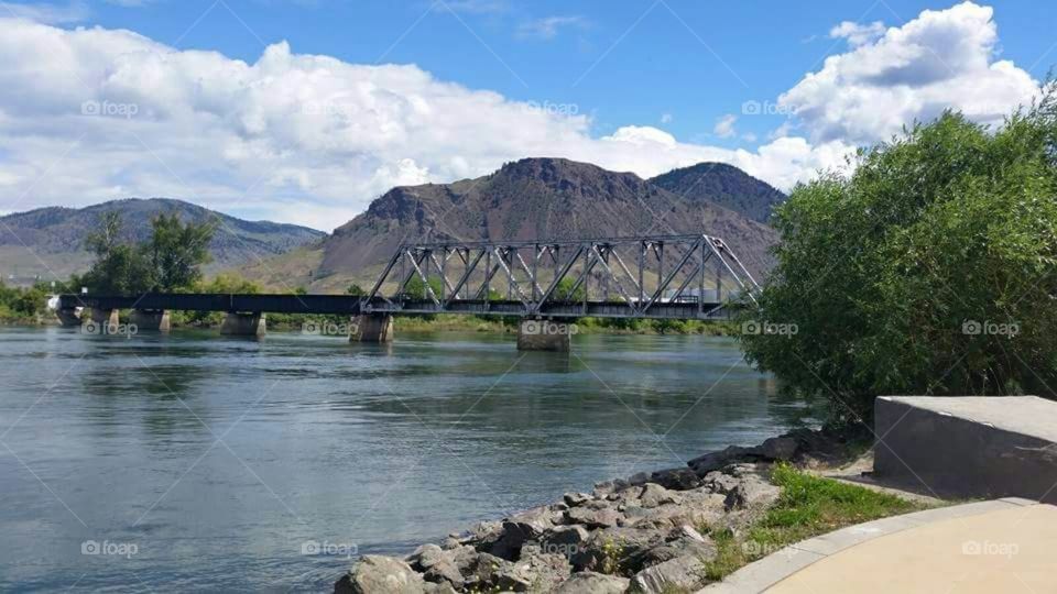 Train bridge across scenic river.