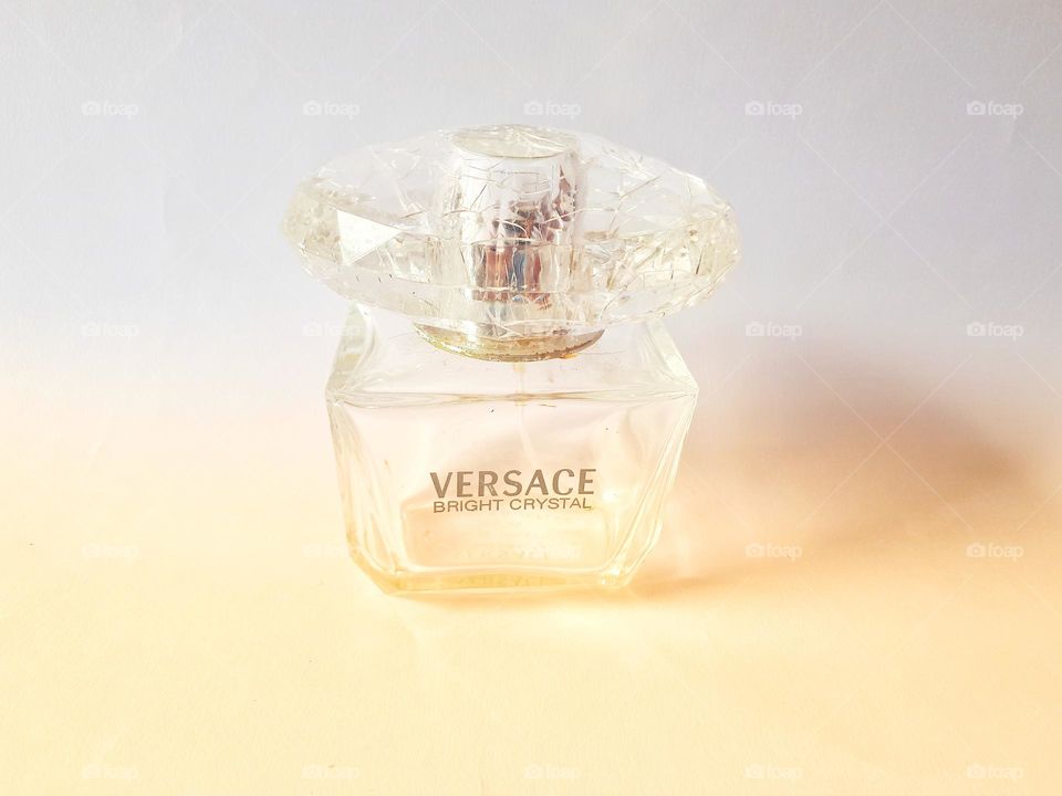 bottle of versace brand perfume on a light background in the evening