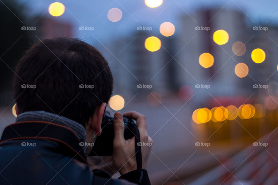 Rear view of a man taking pictures on camera
