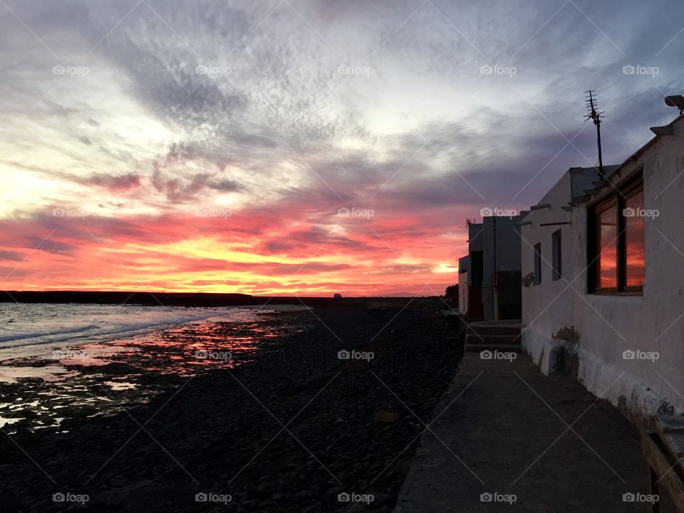 Sunset over sea and Spanish rustic house