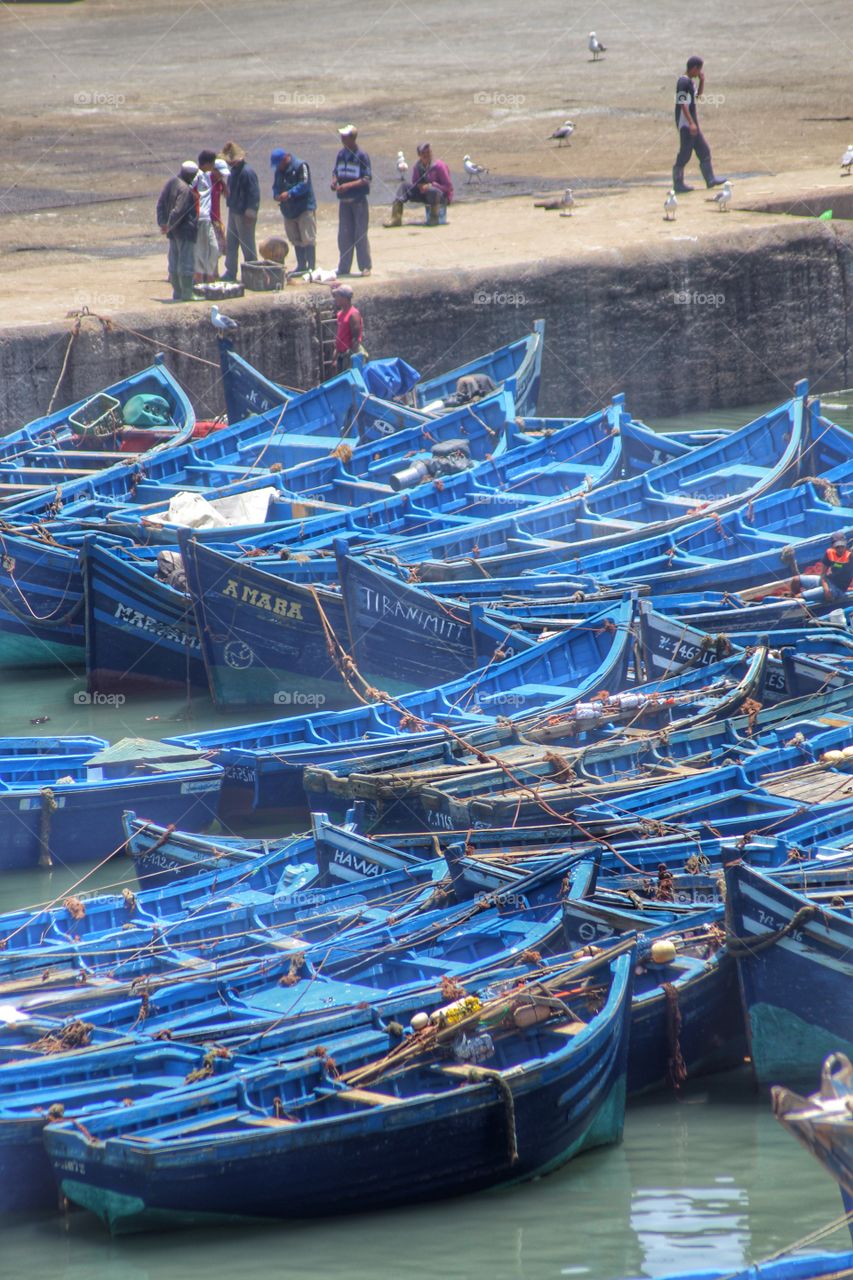 Fishermen and boats . Fishing boats lined up in Essaouira, Morocco.