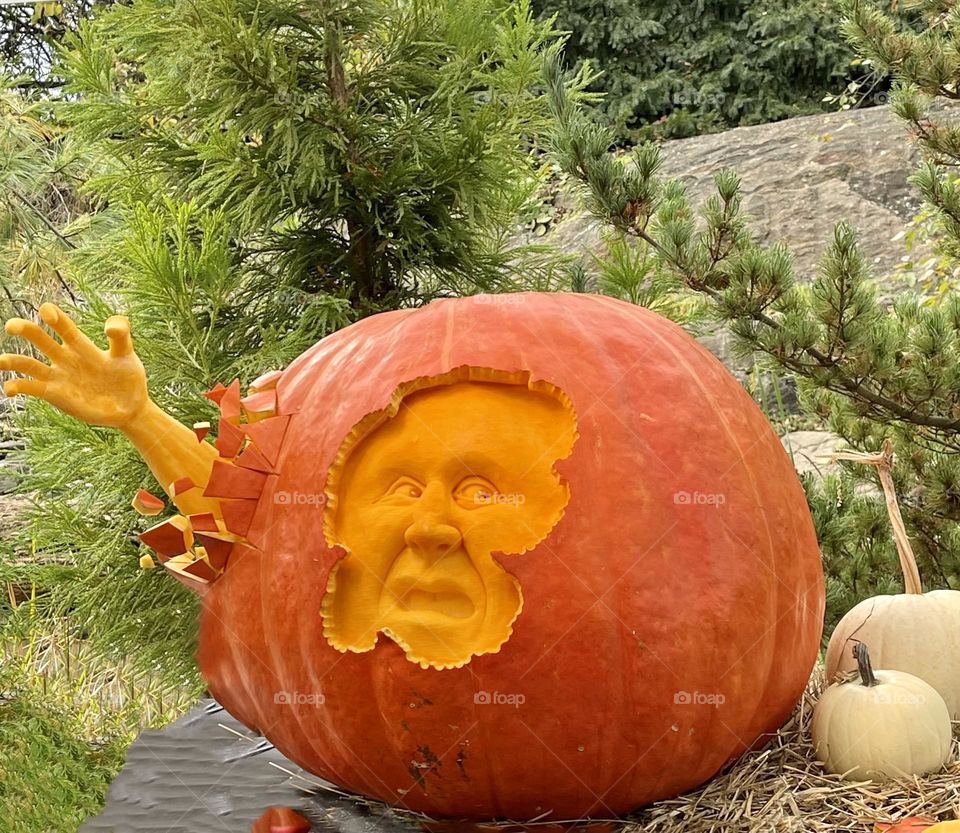 Spooky face with a hand, unique carving design on a pumpkin 