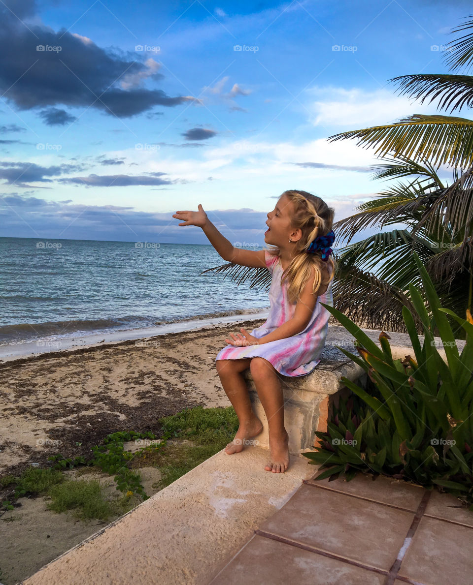 Beautiful girl sitting on bench near sea