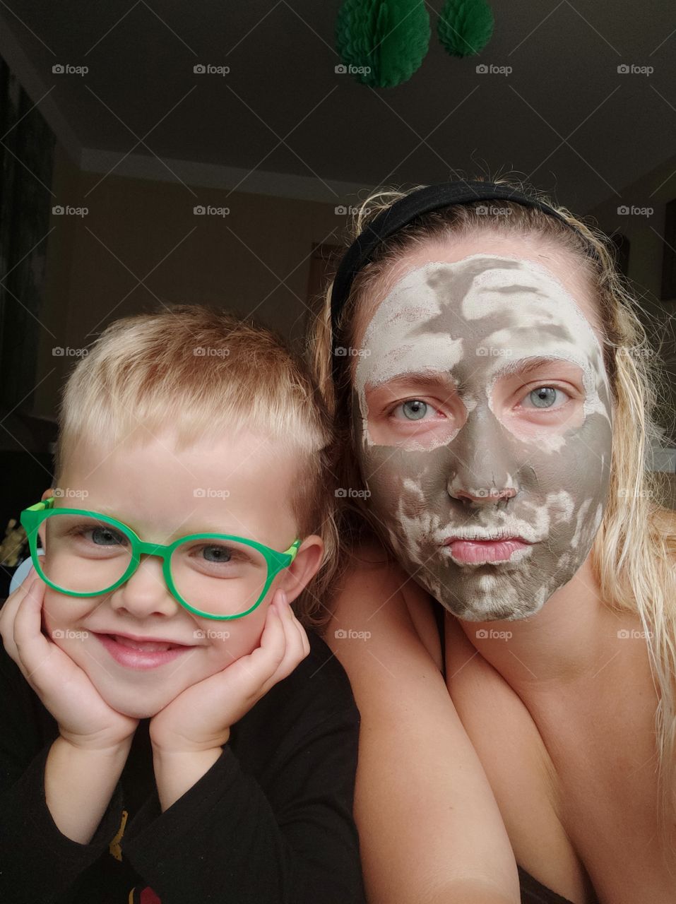 Kid with glasses. mom with clay mask.