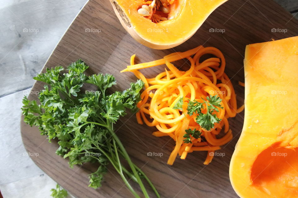 Butternut squash and parsley healthy snack on wood background 