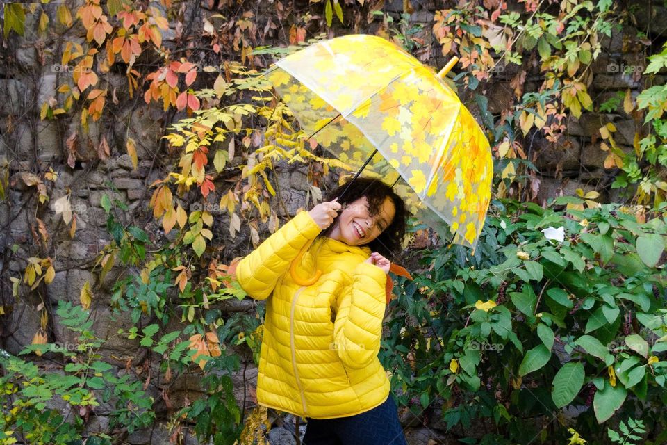 Smiling Woman with Umbrella on Autumn Background