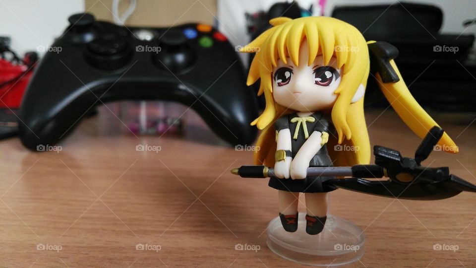 Anime figurine and xbox controller in the background