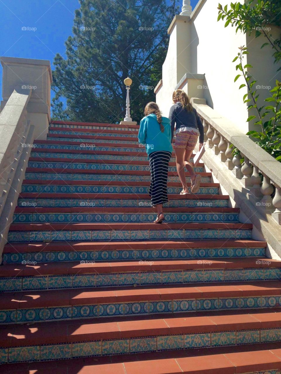 Two girls on a stairway. Two girls climbing an outdoor stairway at Hearst Castle in San Simeon, California.
