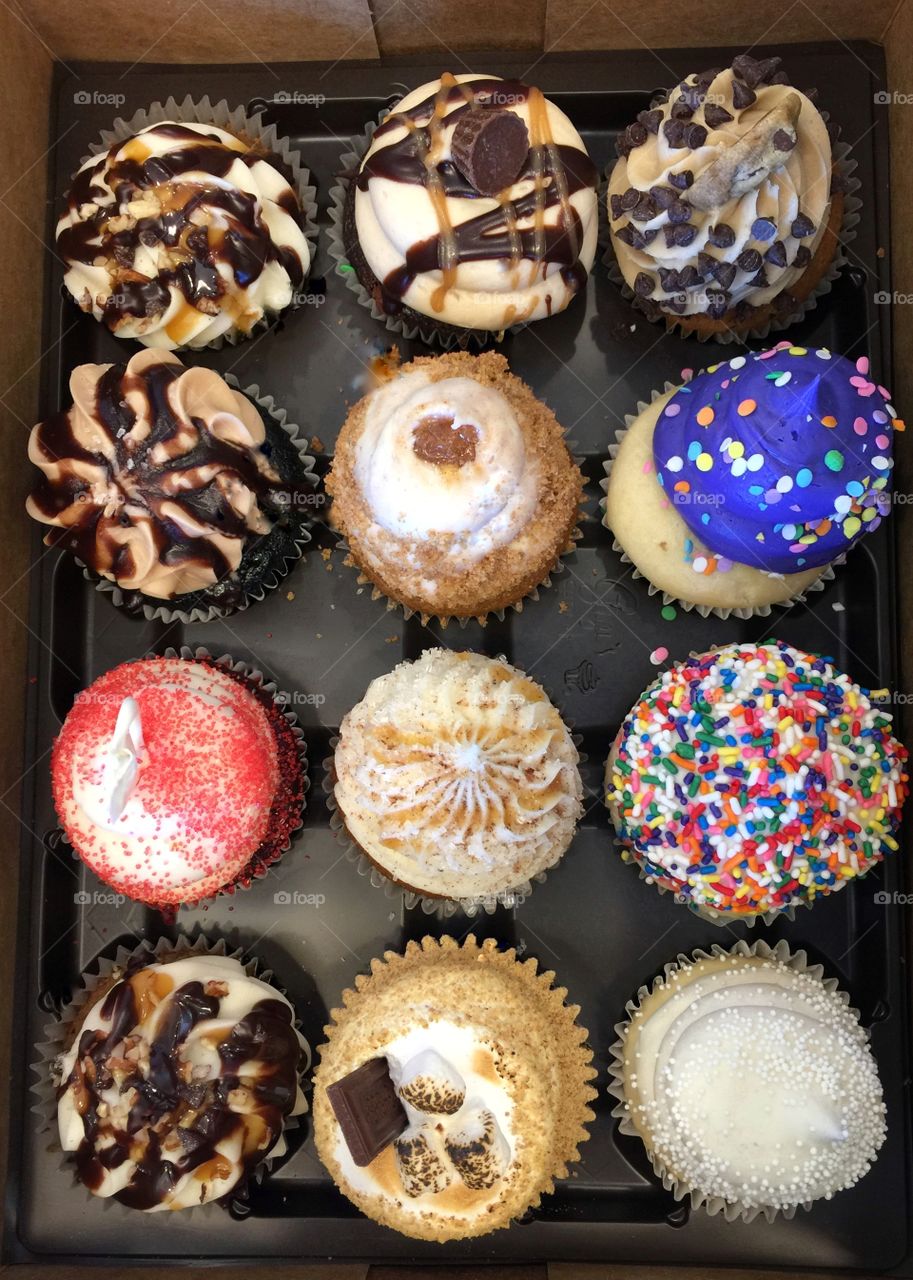 A dozen cupcakes with colorful frosting
