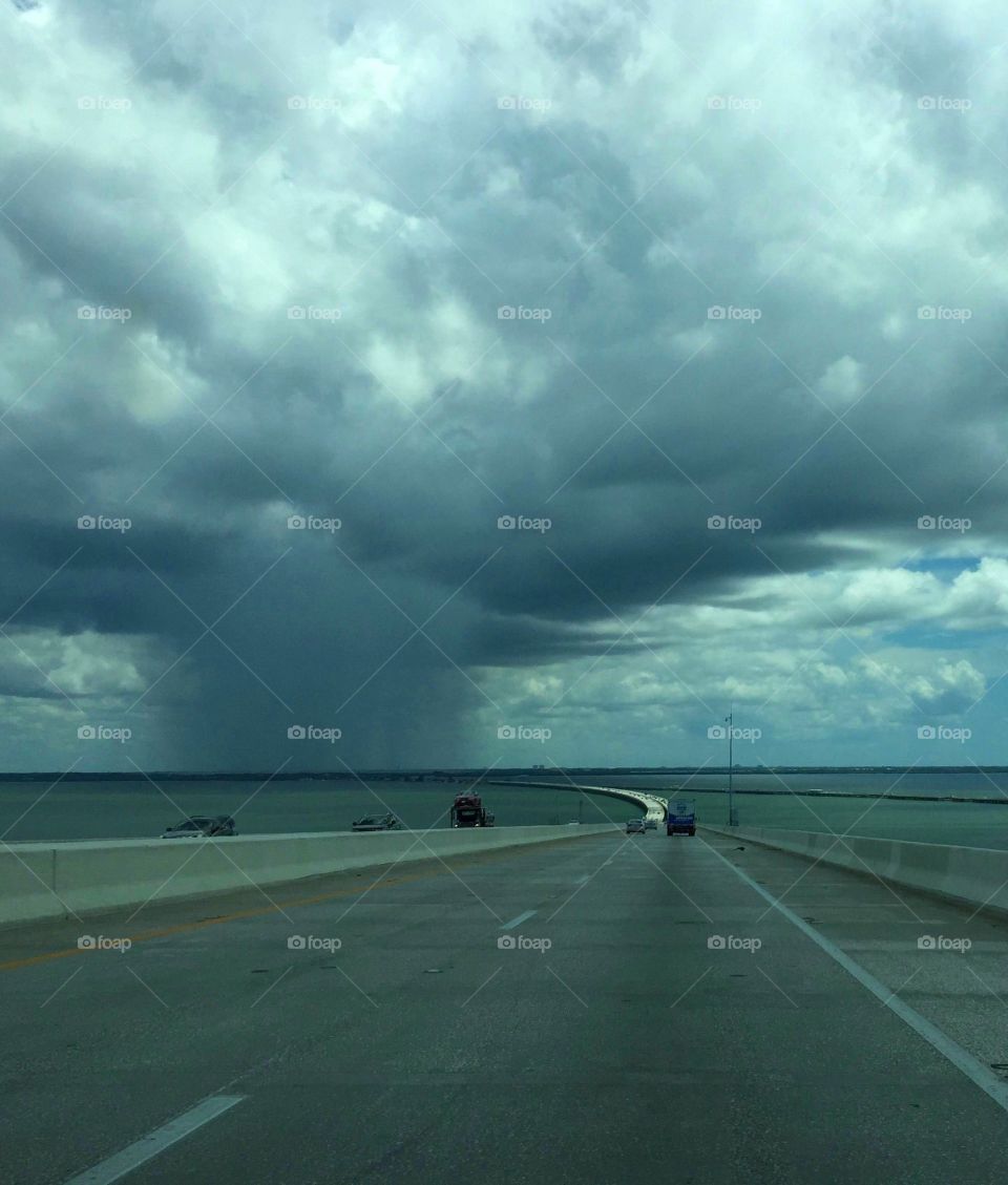 Big storm ahead. Big summer storm viewed from a bridge over the ocean.