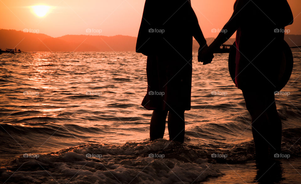 Two people holding hands at sunset krabi