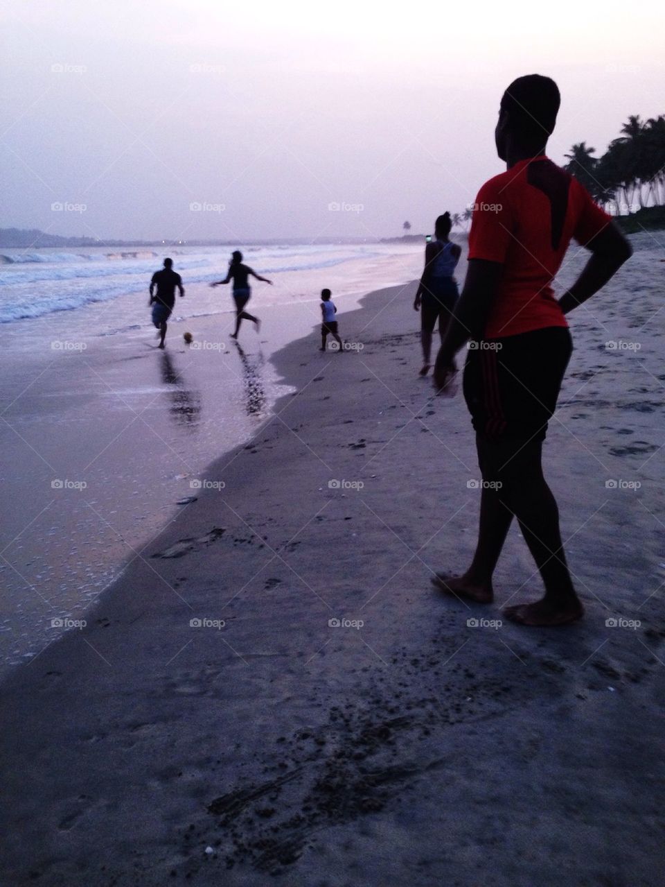 Football on the beach at sunset