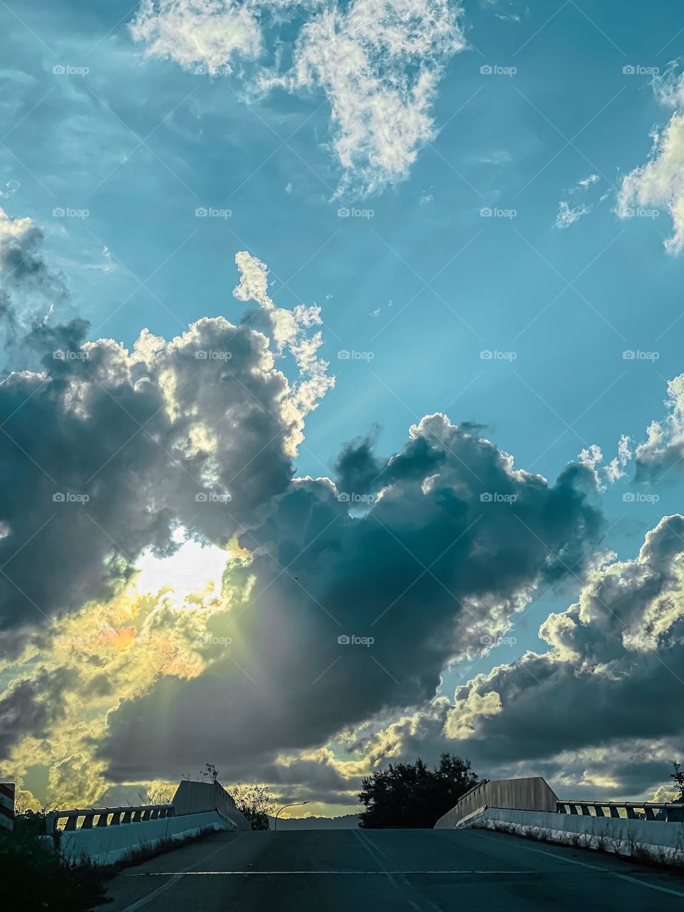 Sun and clouds of a sunset view. Sun rays penetrate through the clouds