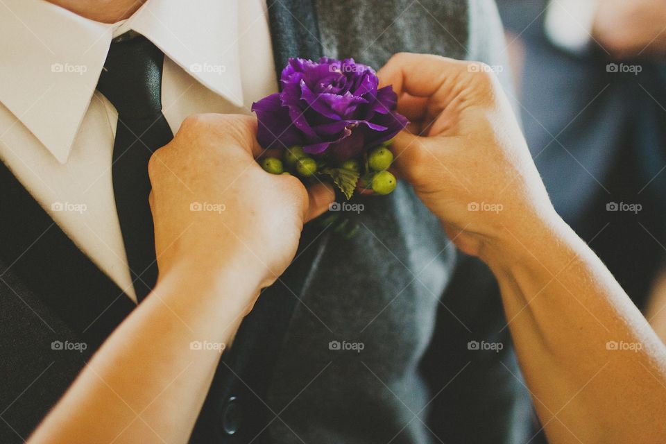 Purple rose boutonniere flower on groom's wedding coat