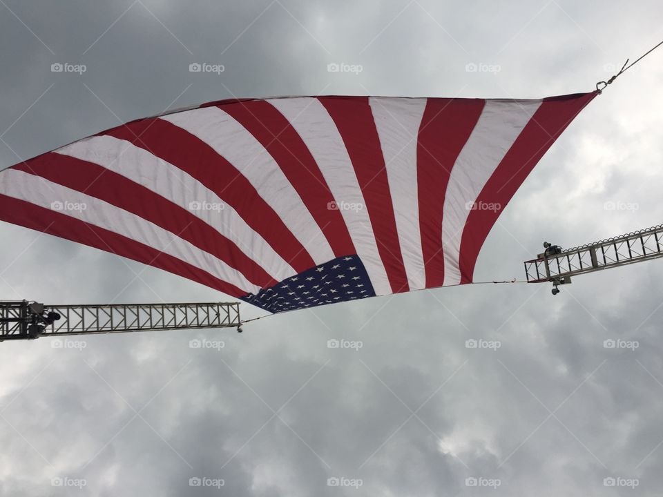 American flag hung from fire truck ladders