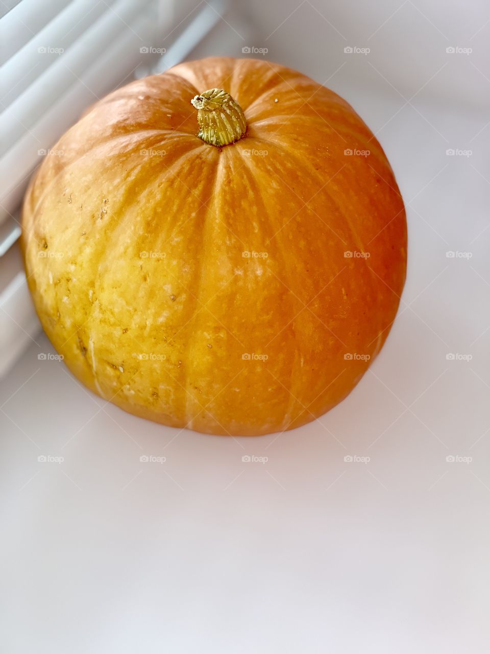 bright orange pumpkin on a white windowsill