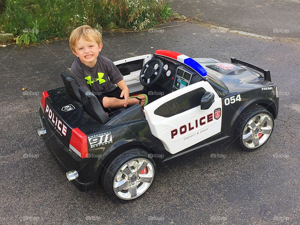 Smiling boy sitting in police car