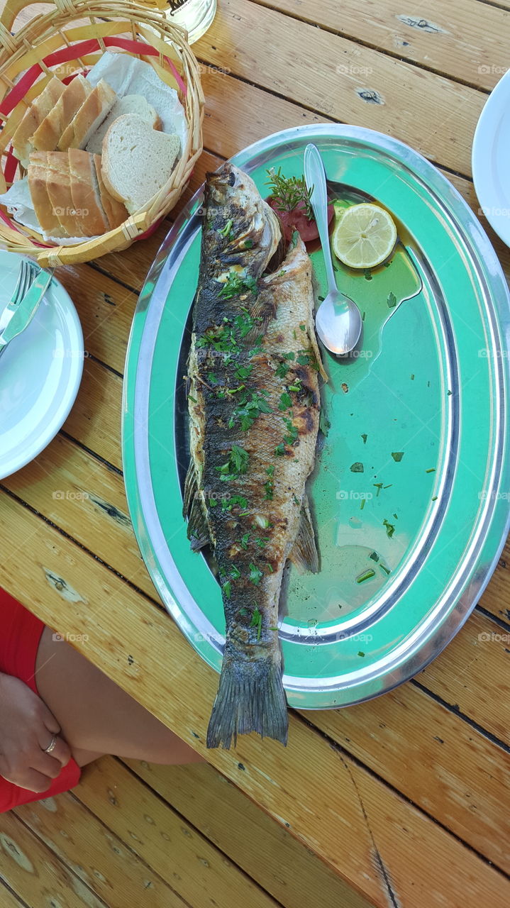 Huge grilled fish shoted near the soup spoon to see the size