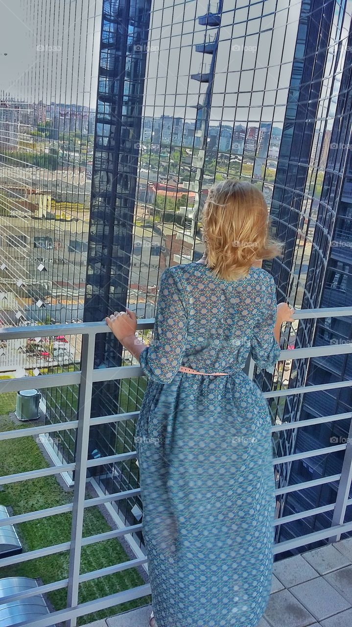 девушка  на фоне зеркального фасада