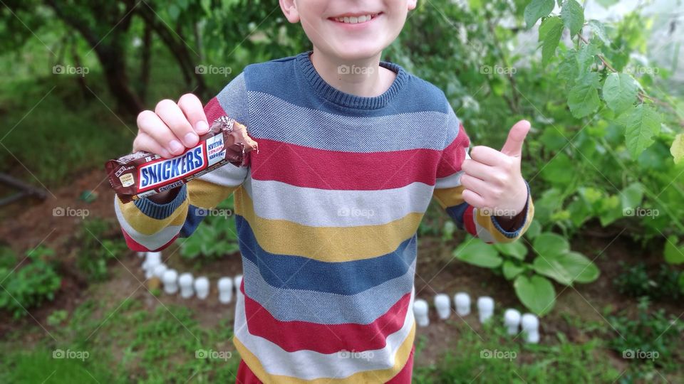 smiling boy holds a snickers