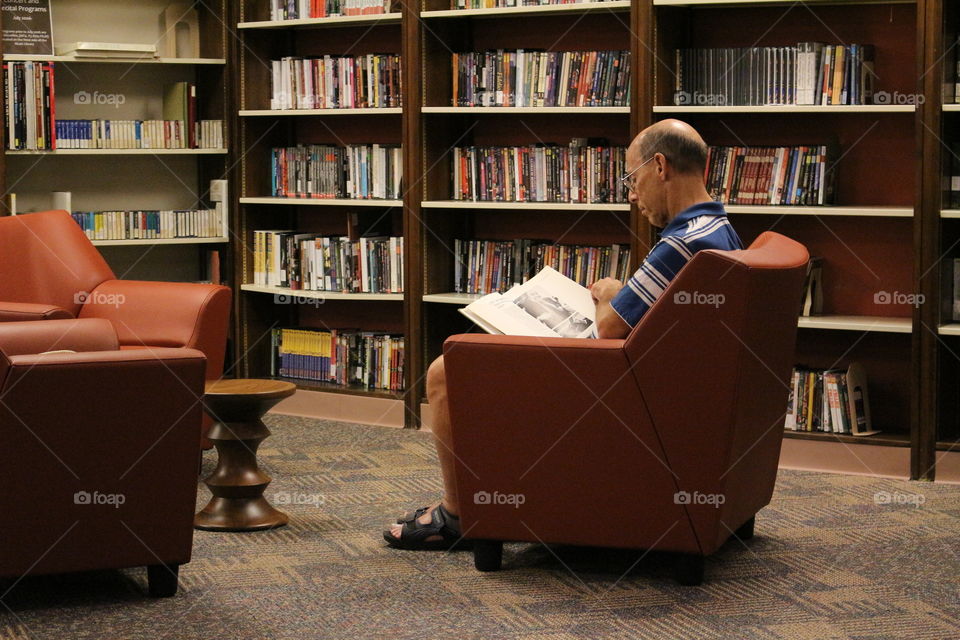 A man reading a book at the library