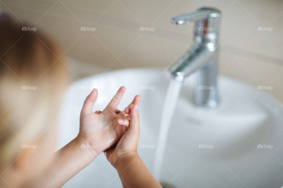 Little girl washing her hands 